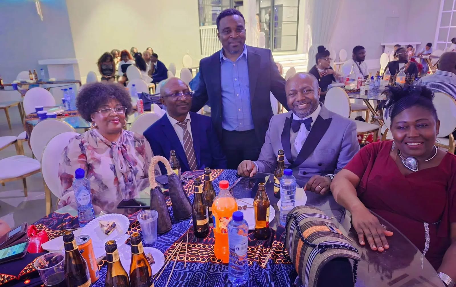 Guests in suits and evening dress around a table dressed in Ndop cloth at the gala